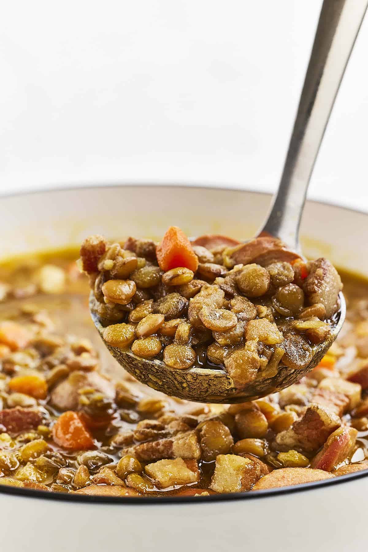 A ladle full of Lentil Soup with Sausage.