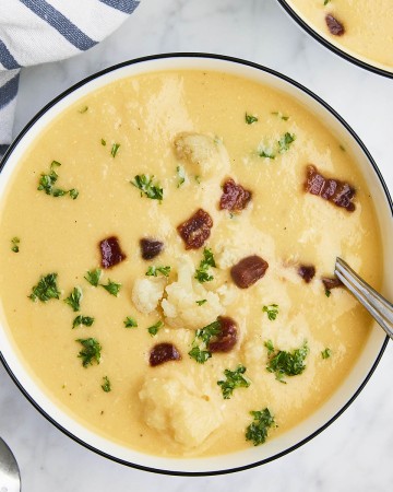 Cheesy Cauliflower Soup in a white bowl.