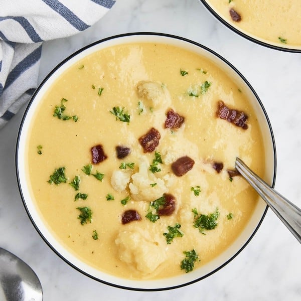 Cheesy Cauliflower Soup in a white bowl.