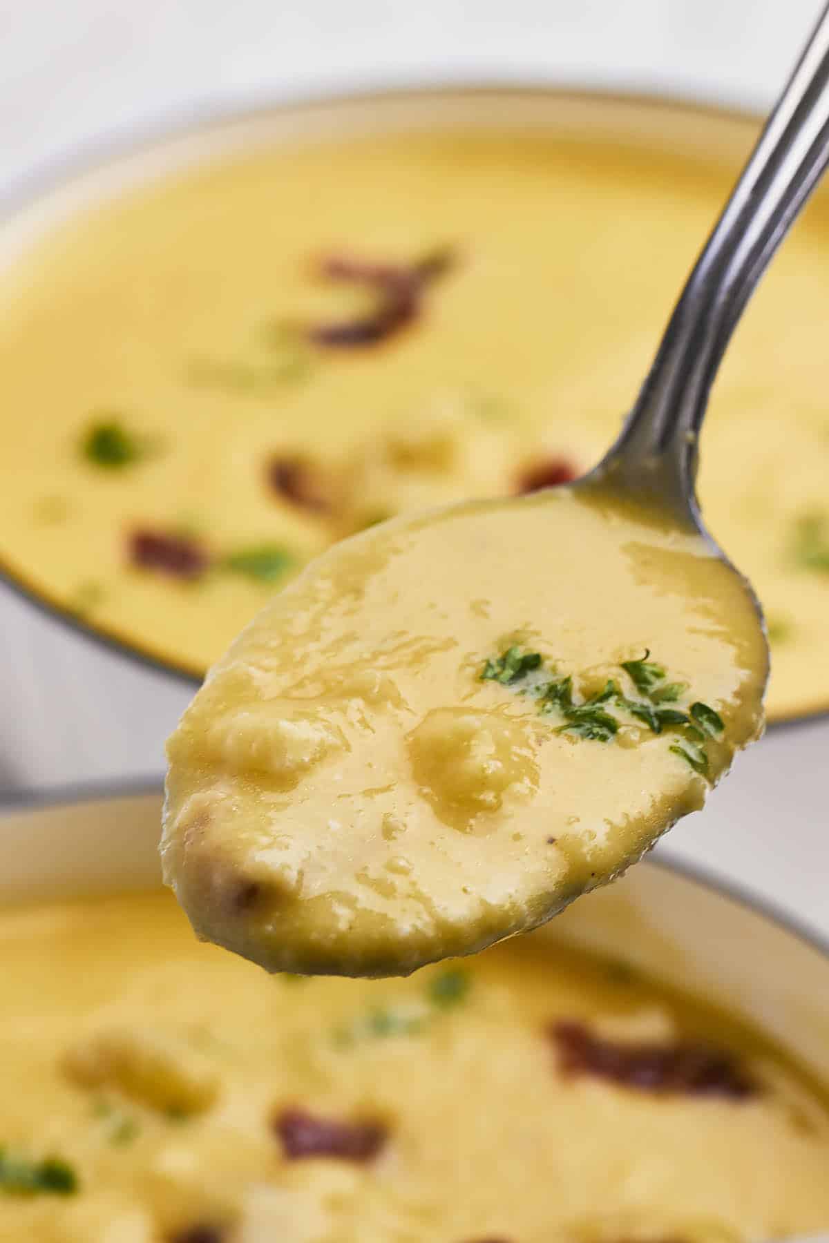 A spoonful of warm Cheesy Cauliflower Soup. 