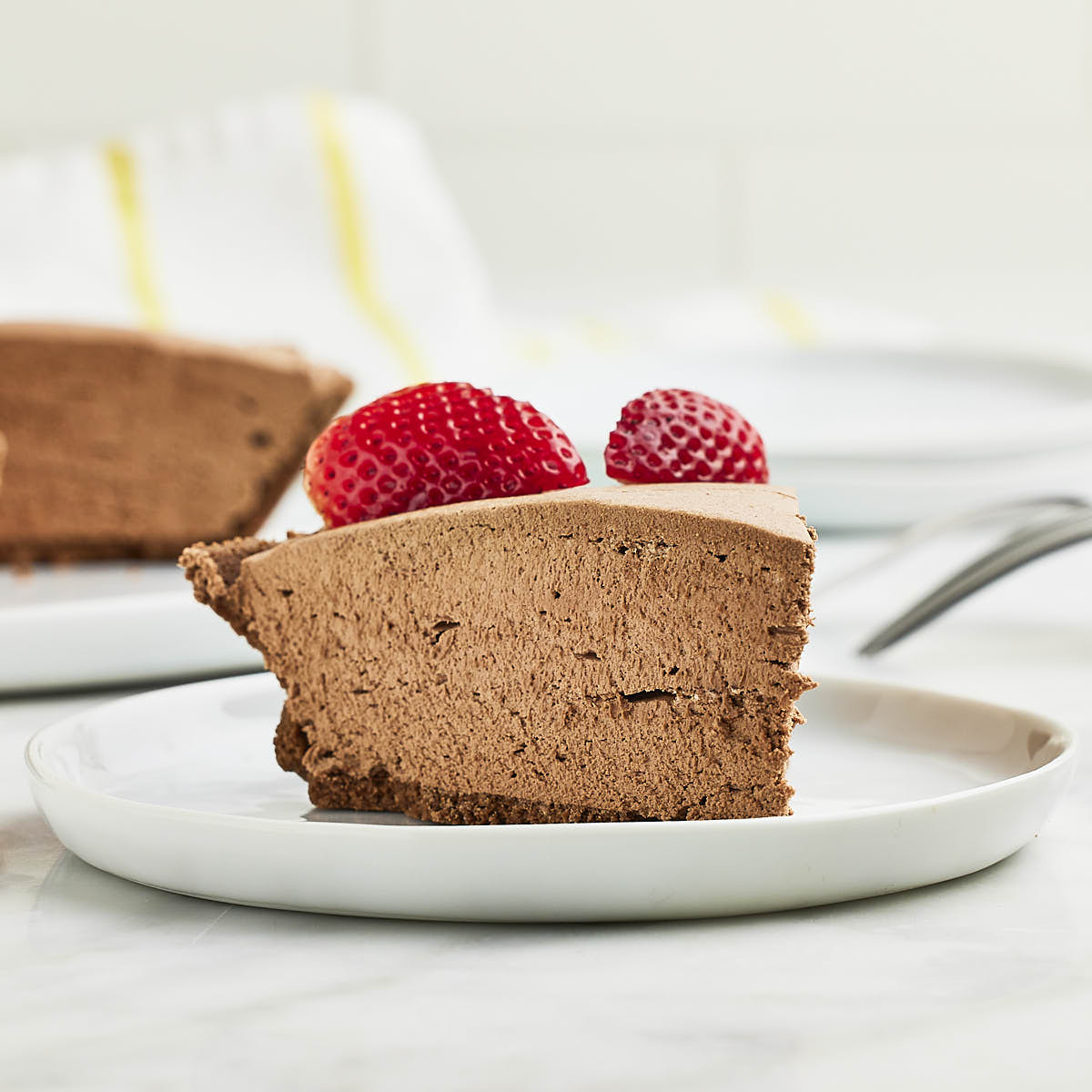 Closeup of a Chocolate Cheesecake on a white plate.
