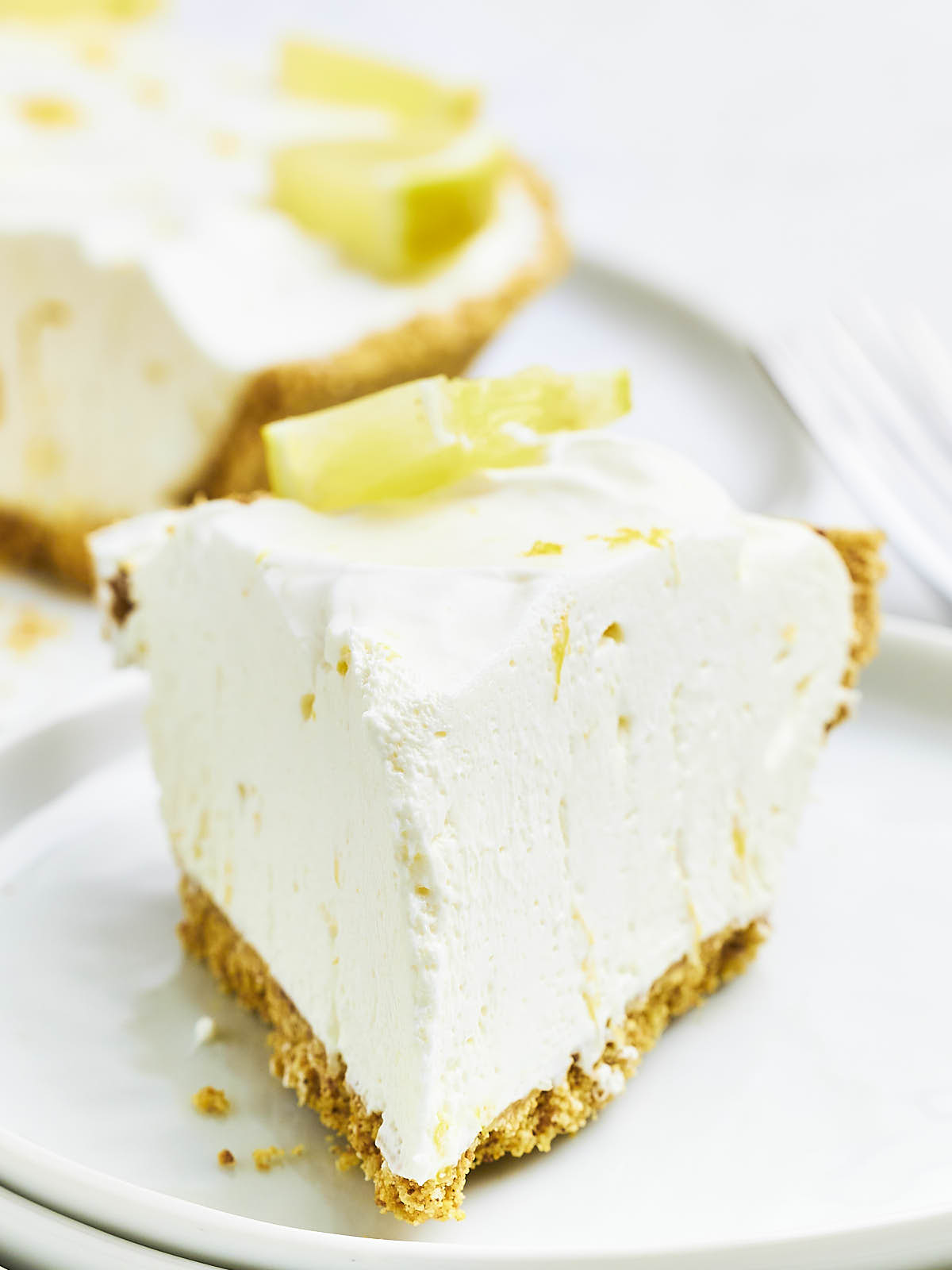 A slice of Lemon Icebox Pie on a white plate. 