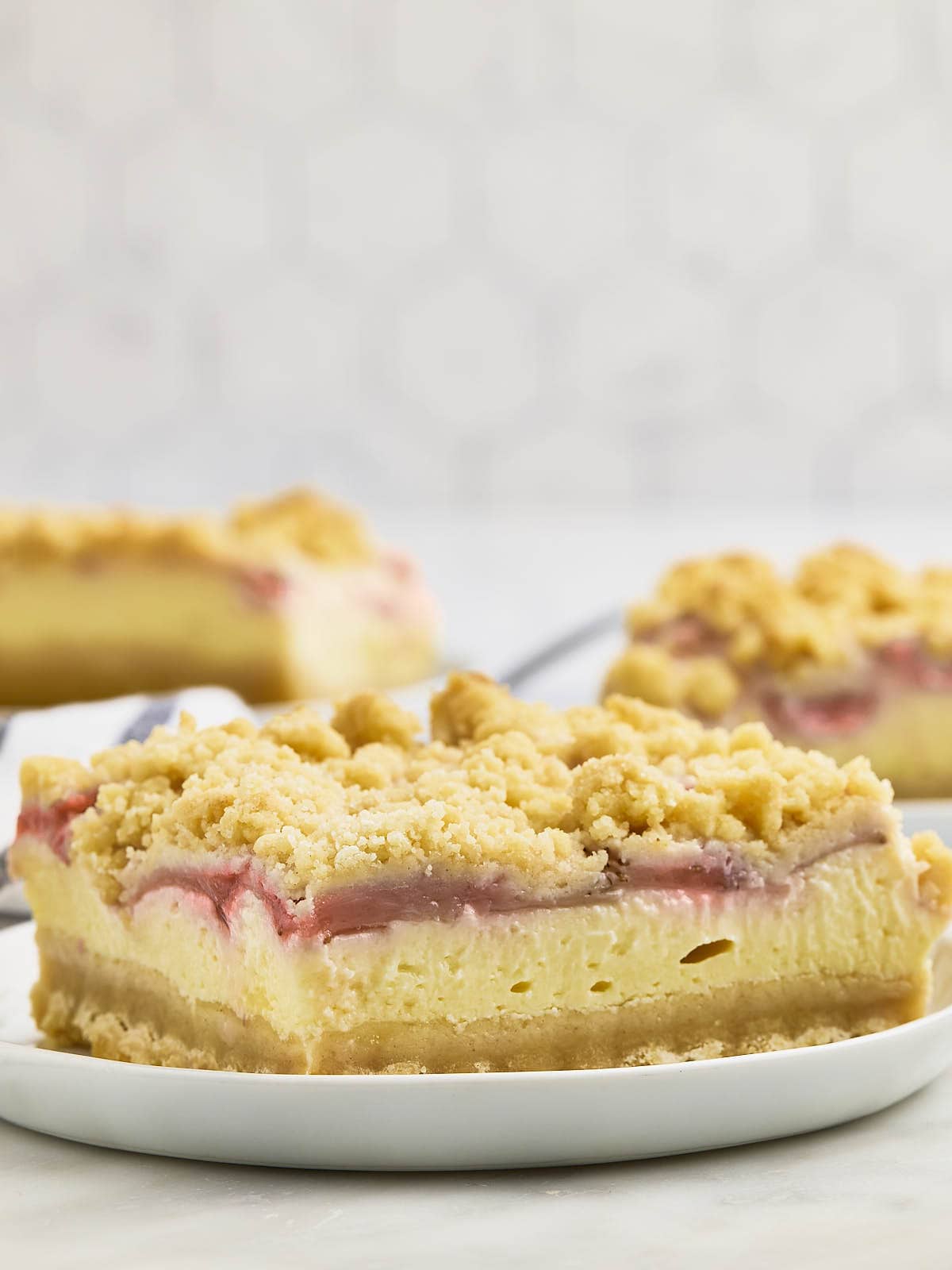 Closeup of a Strawberry Cheesecake Bar on a white plate. 