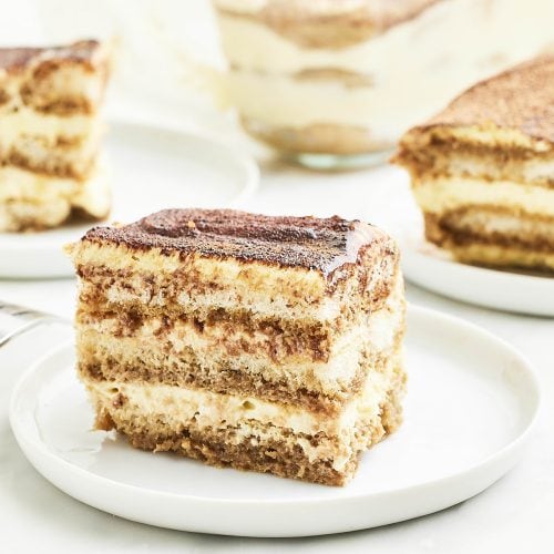 Closeup of a slice of Tiramisu on a white plate.