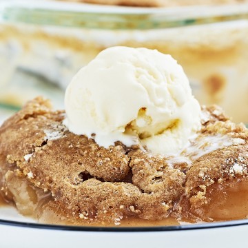 Closeup of an Apple Spice Dump Cake served with a scoop of vanilla ice cream.