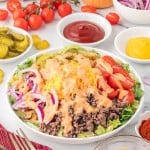 Big Mac Salad in a white bowl topped with dressing.