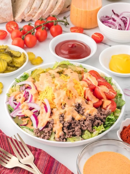 Big Mac Salad in a white bowl topped with dressing.
