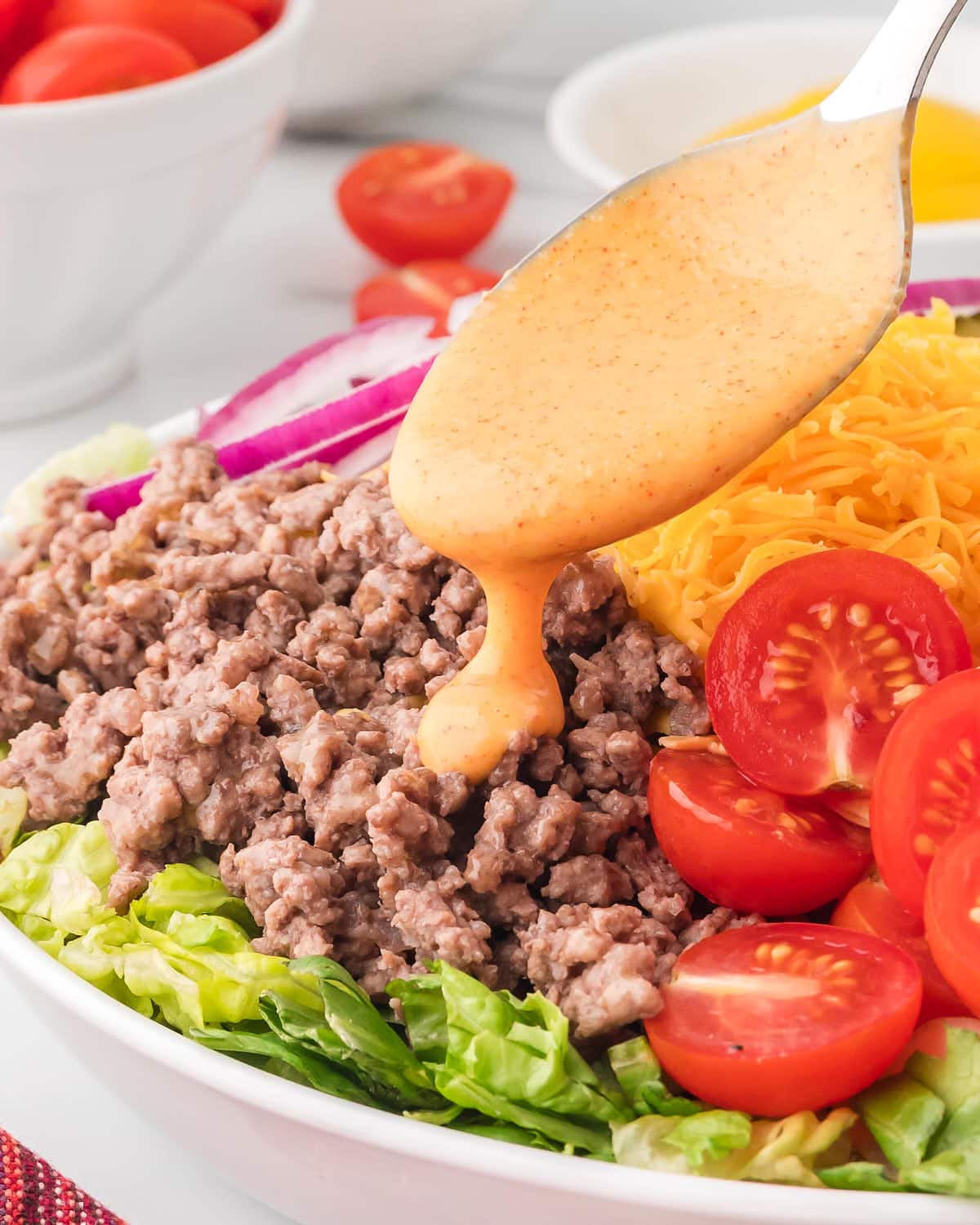 Pouring dressing over the Big Mac Salad.