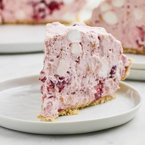 A slice of Cherry Pineapple Pie on a white plate.