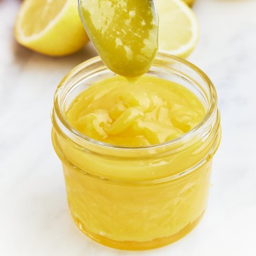 Closeup a bowl of homemade Lemon Curd in a glass jar.