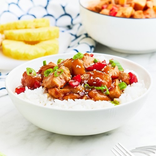 Closeup of a bowl of Hawaiian Chicken served over rice in a white bowl.