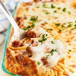 Closeup of a large scoop of cheesy baked Titktok Spaghetti pasta in a casserole dish.
