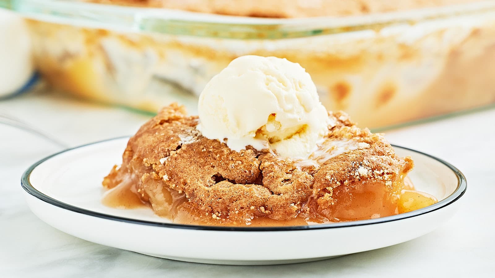 Closeup of an Apple Spice Dump Cake served with a scoop of vanilla ice cream.