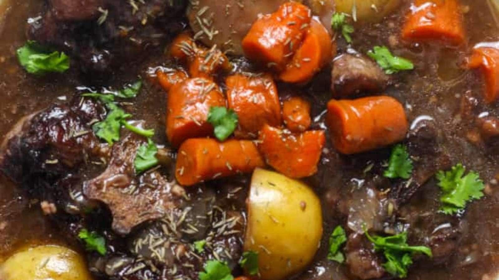 Beef chunks, potatoes, and carrots in a bowl.