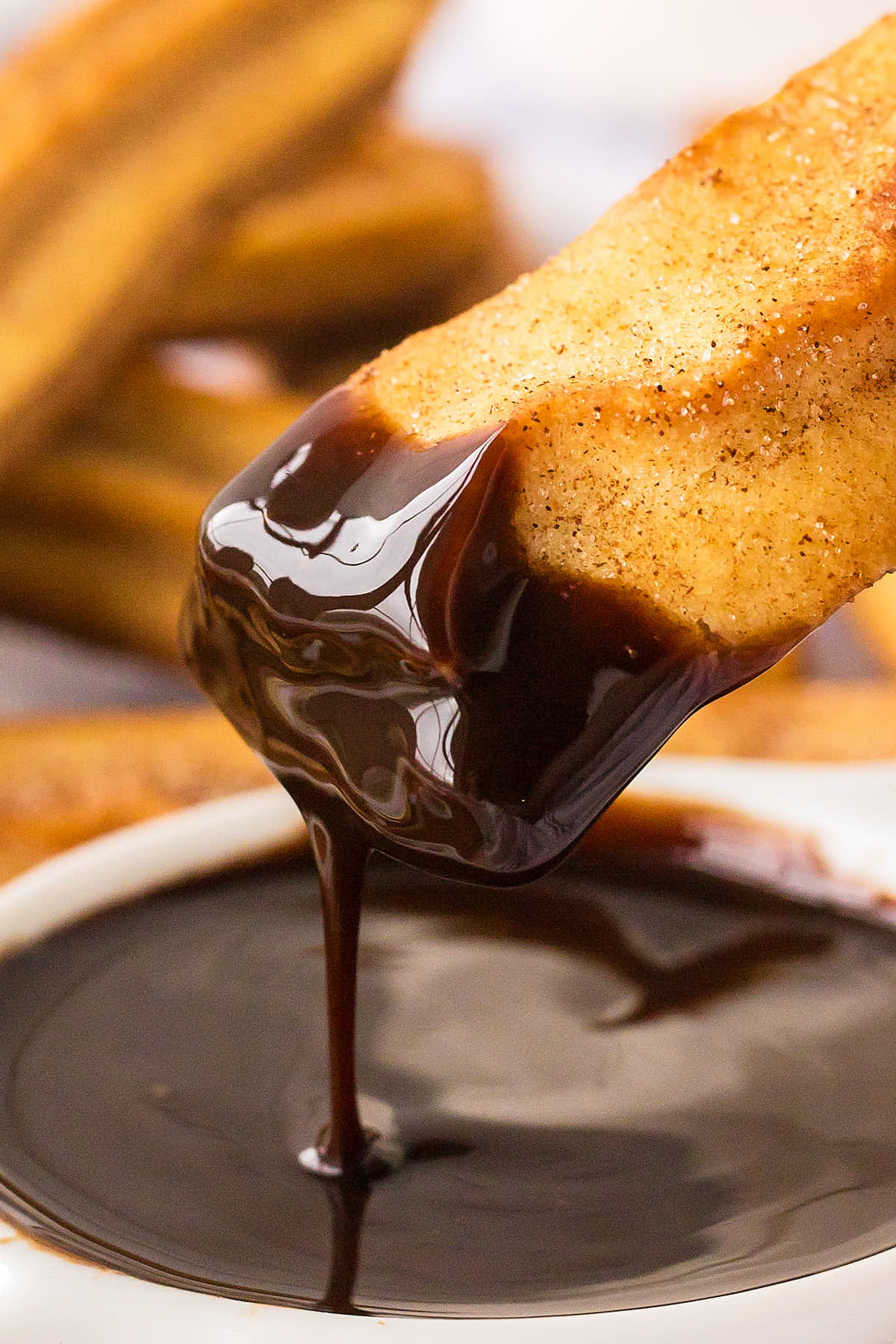 A baked Churro dipped in Chocolate.