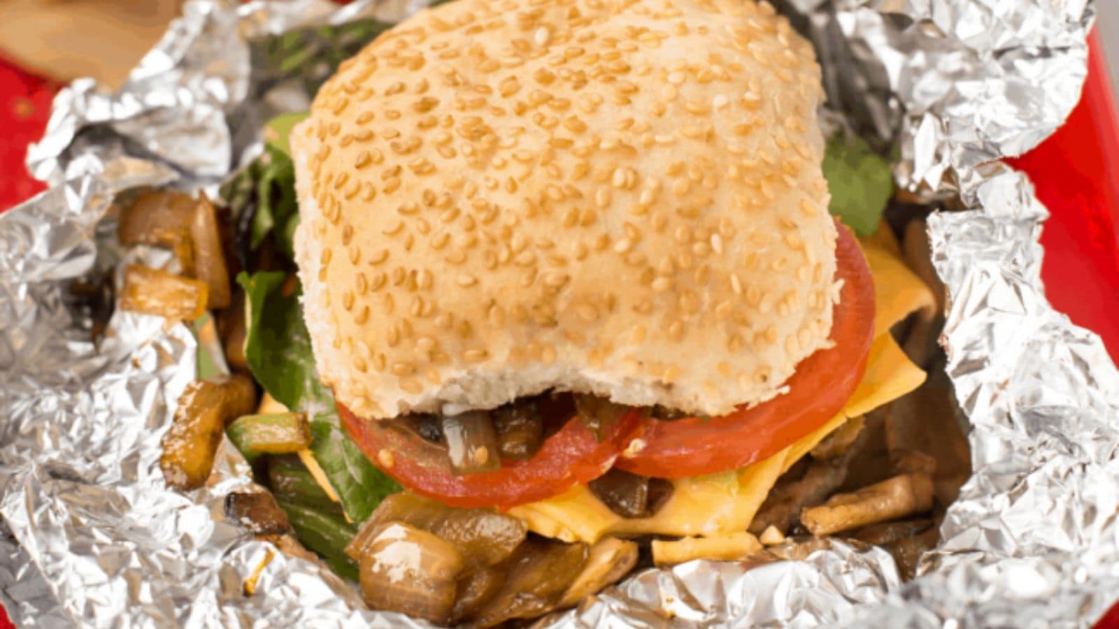 A grilled veggie and cheese sandwich on a bun.