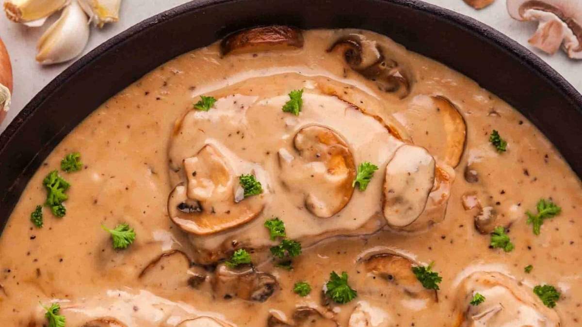 A skillet filled with mushrooms and gravy.