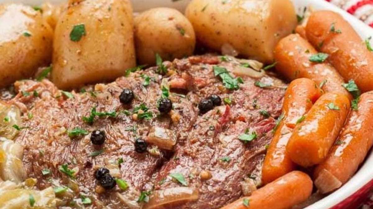 A bowl of roast beef with carrots and potatoes.