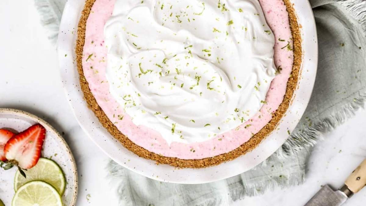 A no-bake strawberry pie with whipped cream and a slice of lime.