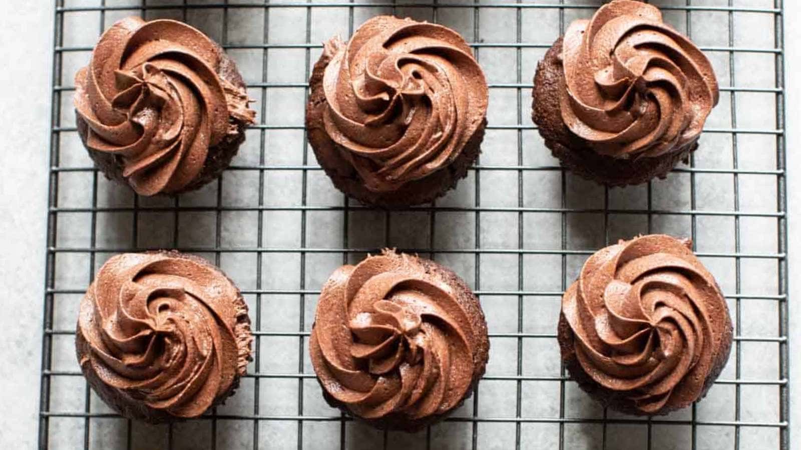 Chocolate cupcakes on a cooling rack waiting to be devoured.