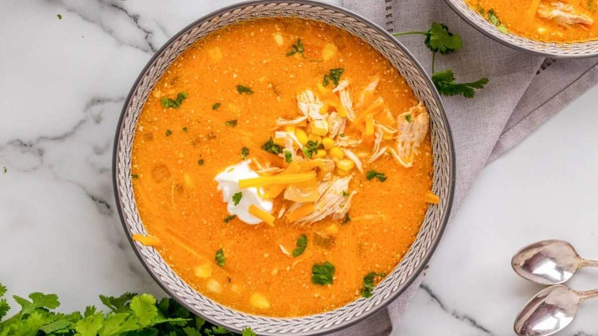 Two bowls of mexican chicken soup on a marble table.