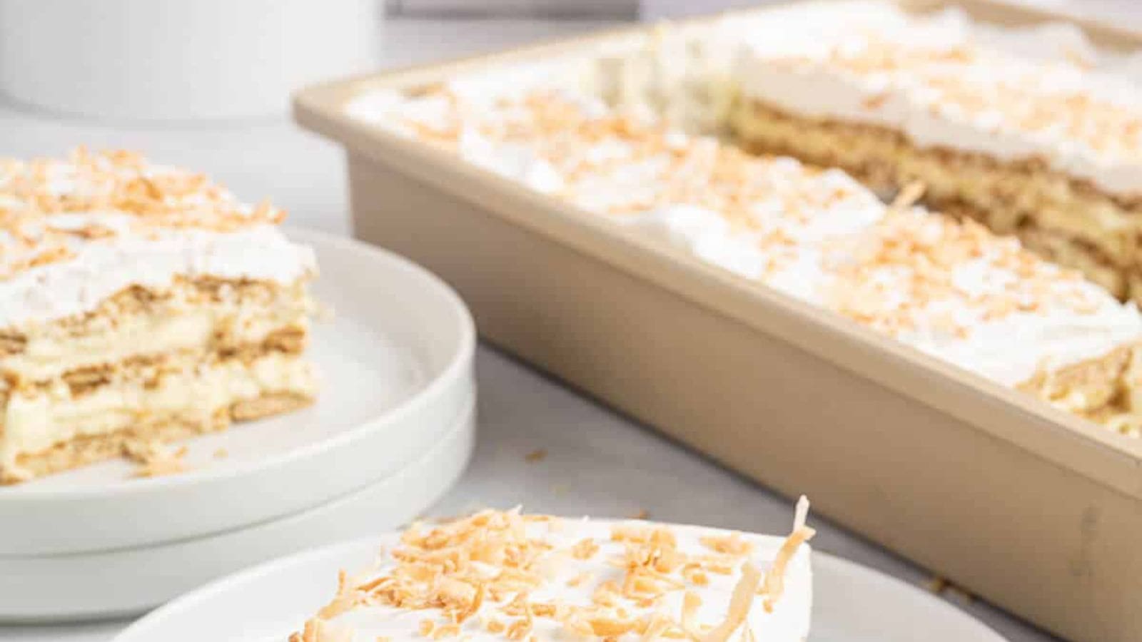 Coconut icebox cake with layers of whipped topping and graham crackers.