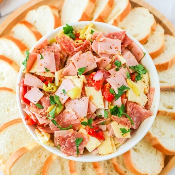 An Italian Hoagie Dip with bread and pickles.
