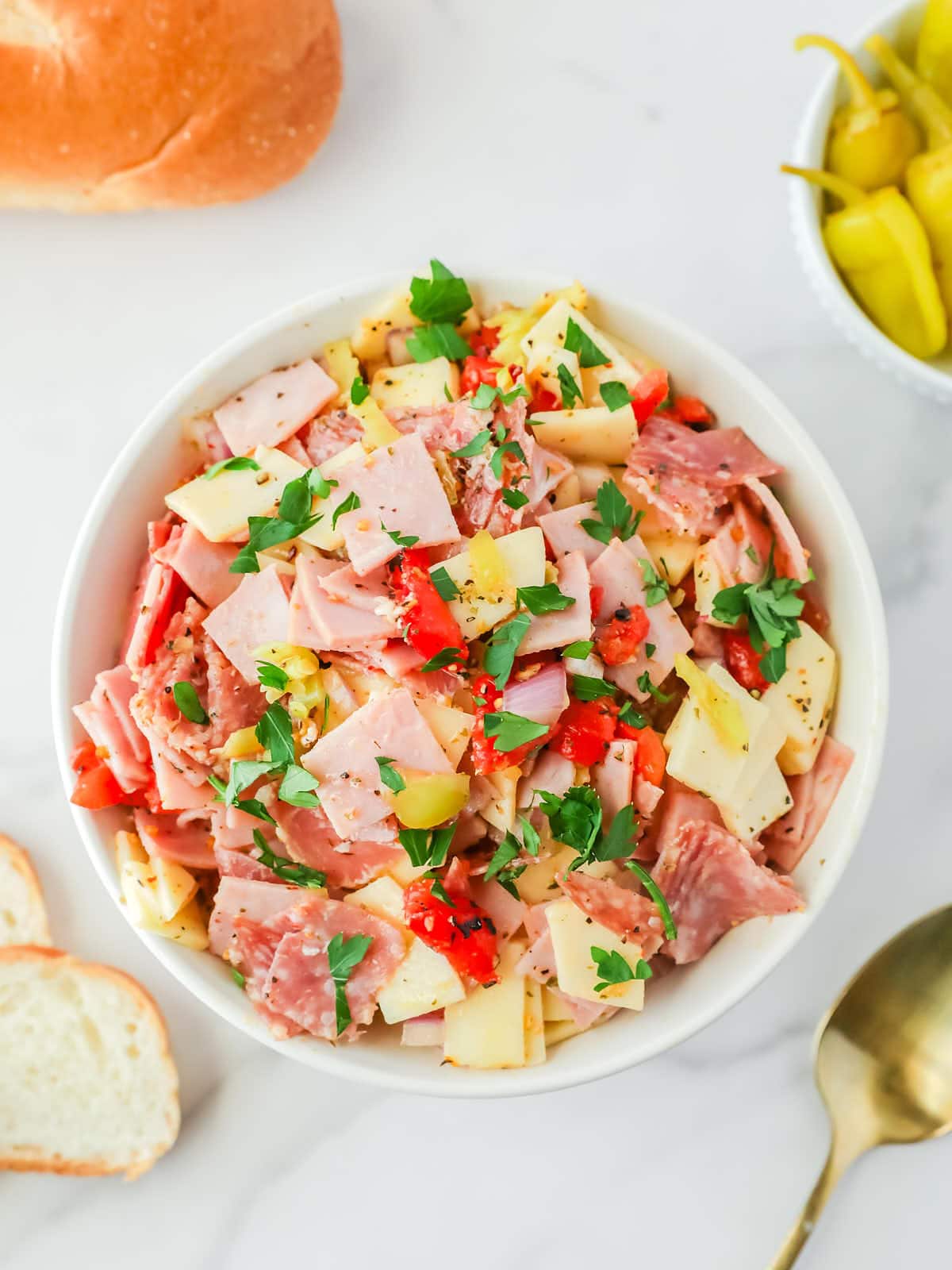 A bowl of Italian Hoagie Dip with peppers and pickles.