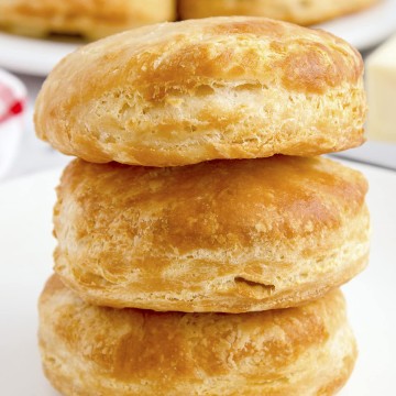 Air Fryer biscuits stacked on a white plate.