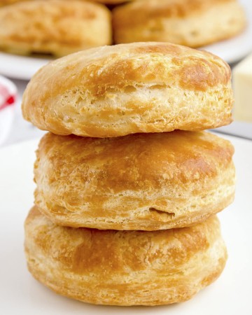 Air Fryer biscuits stacked on a white plate.