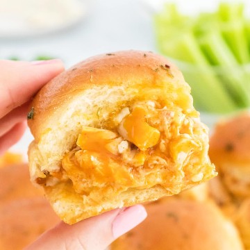 A hand holding up a Buffalo Chicken Sliders.