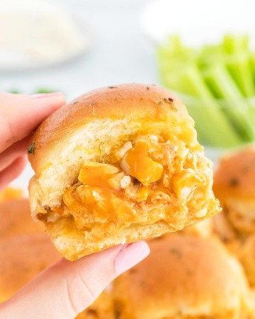A hand holding up a Buffalo Chicken Sliders.
