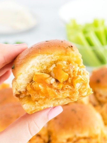 A hand holding up a Buffalo Chicken Sliders.