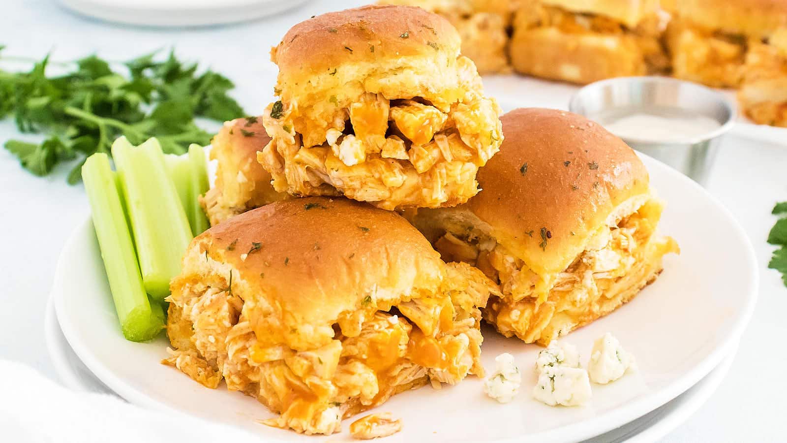 Buffalo Chicken Sliders on a plate with celery.