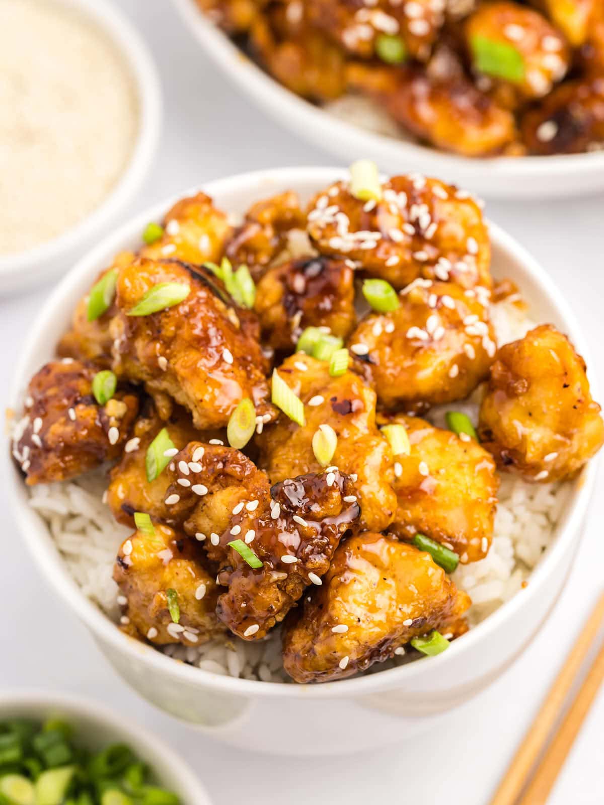 A bowl of Honey Garlic Chicken with rice and sesame seeds.