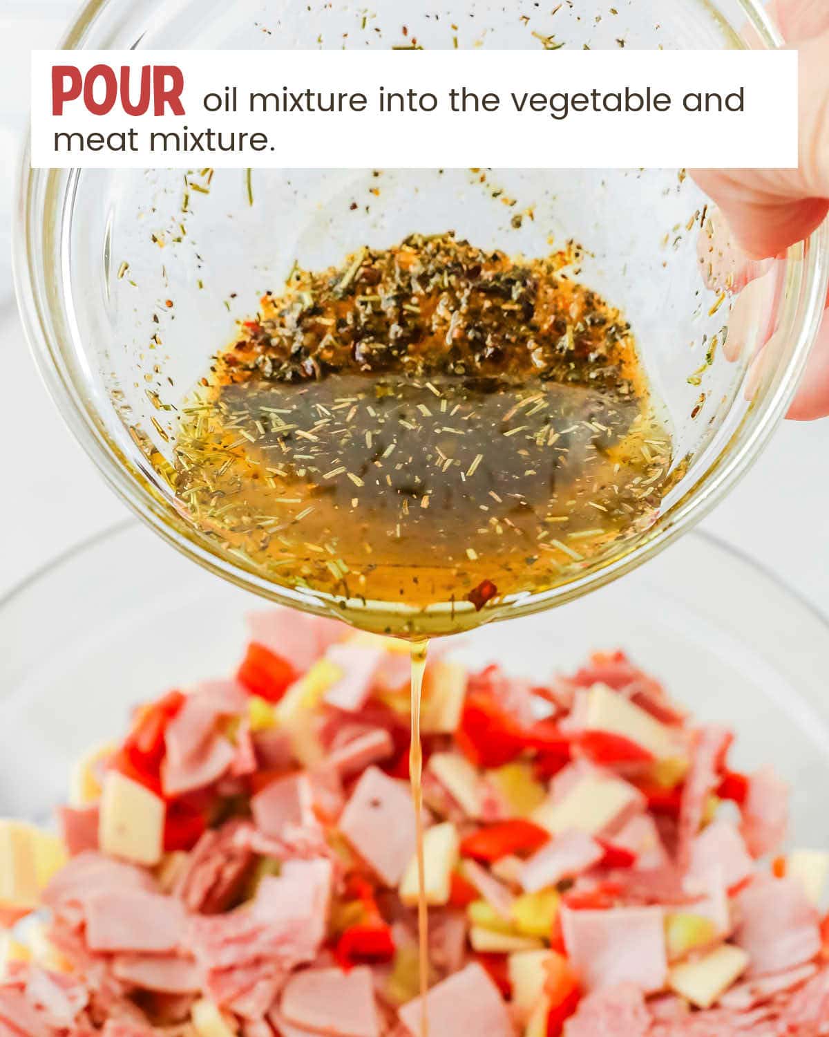 Pouring oil and seasonings in bowl with diced deli meats and vegetables
