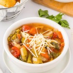 A Minestrone soup with bread on a table.