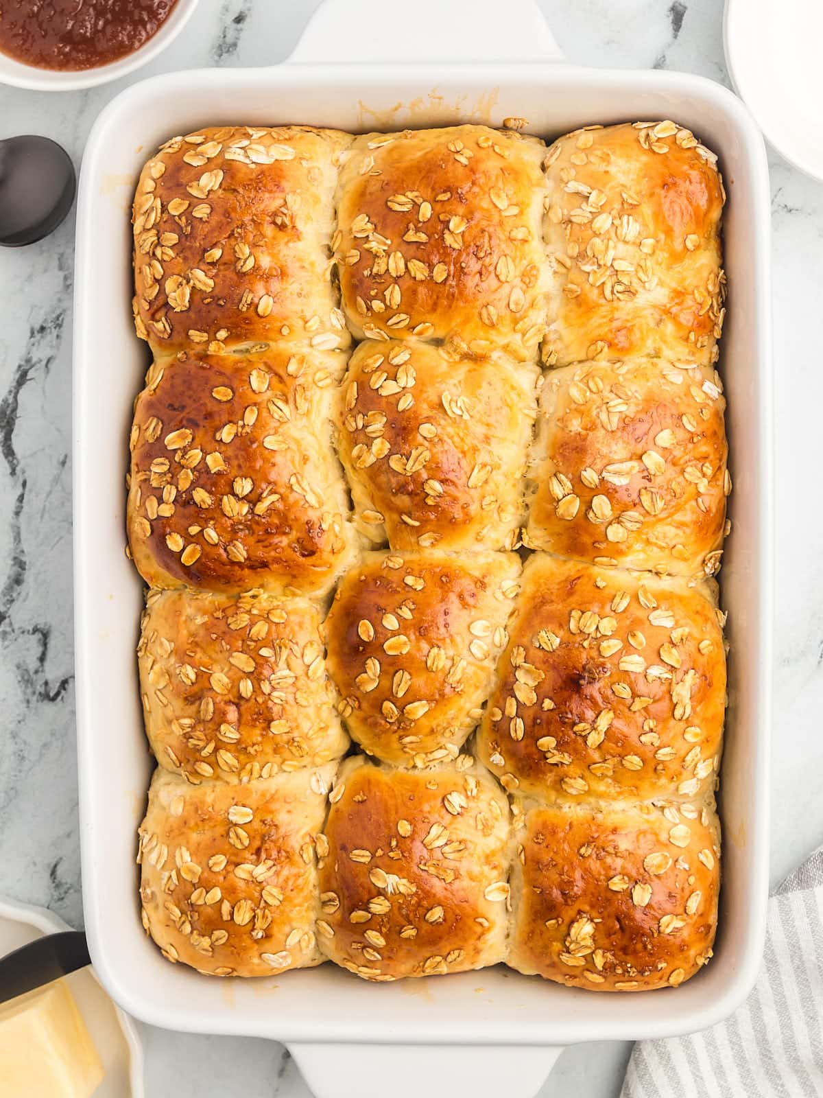 A baking dish filled with Oatmeal Rolls and oats.