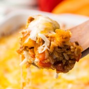 A fork is being used to take a piece of Stuffed Pepper Casserole out of a casserole dish.