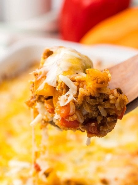 A fork is being used to take a piece of Stuffed Pepper Casserole out of a casserole dish.