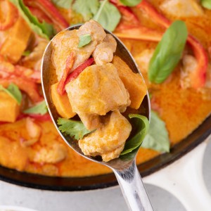 Thai Red Curry Chicken served on a spoon with rice.