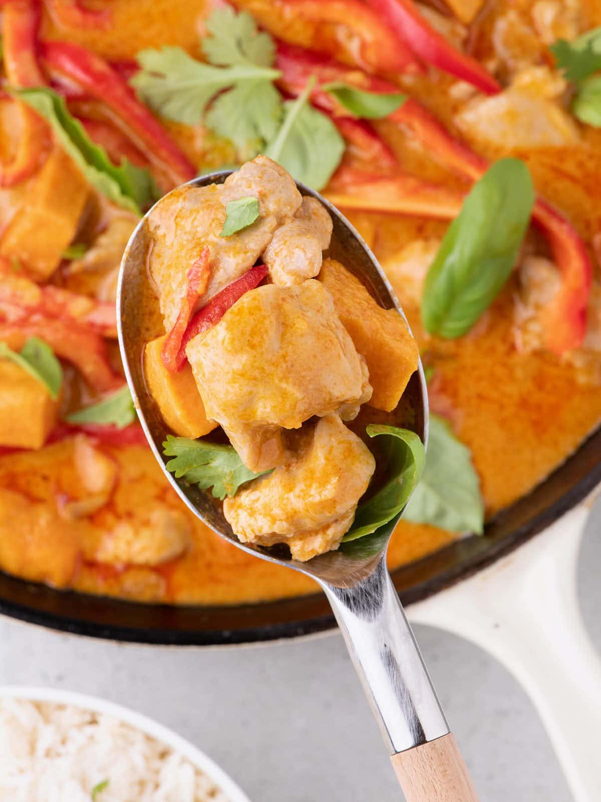 Thai Red Curry Chicken served on a spoon with rice.