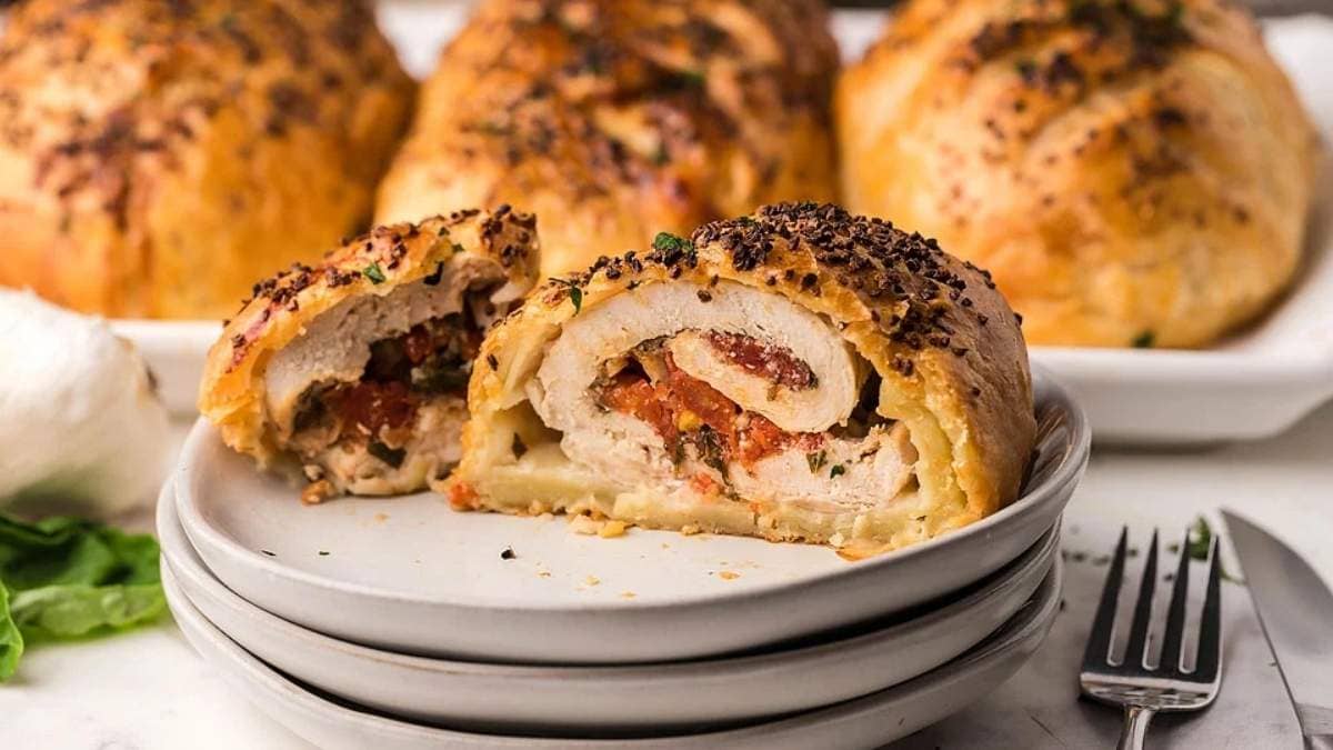 A plate of chicken stuffed pastries on a white plate.