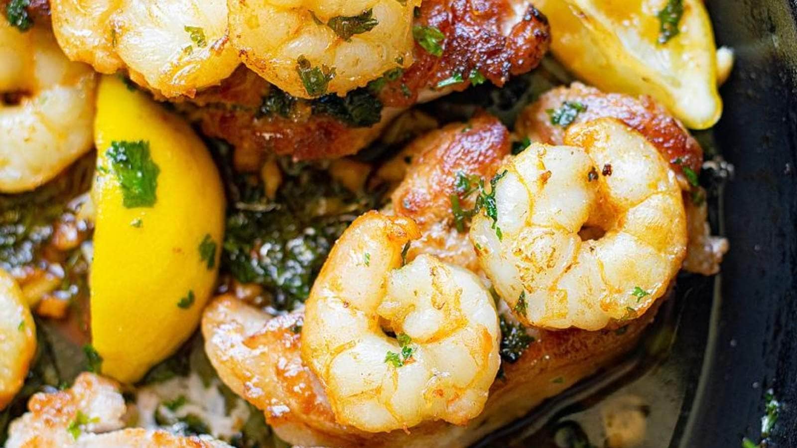 A plate with shrimp and lemons on it.