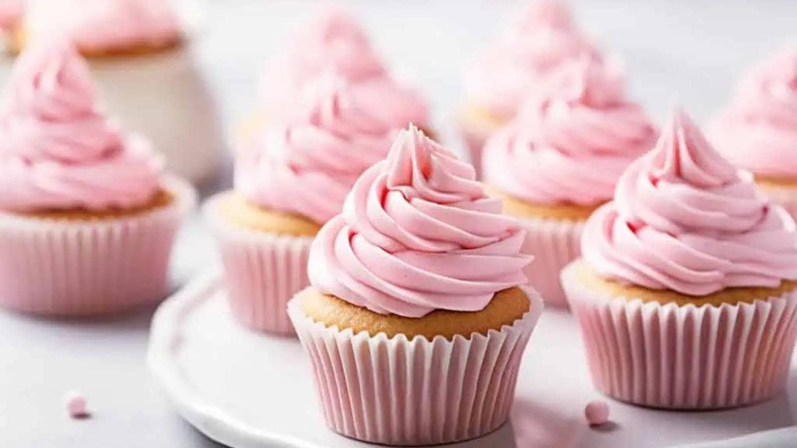 A group of cupcakes with pink frosting.