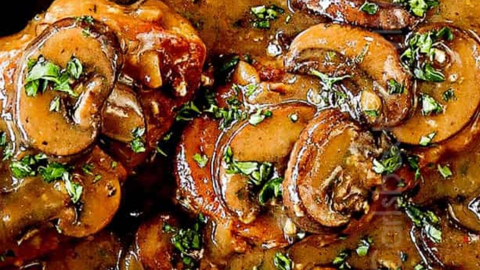 A close up of mushrooms and gravy in a skillet.