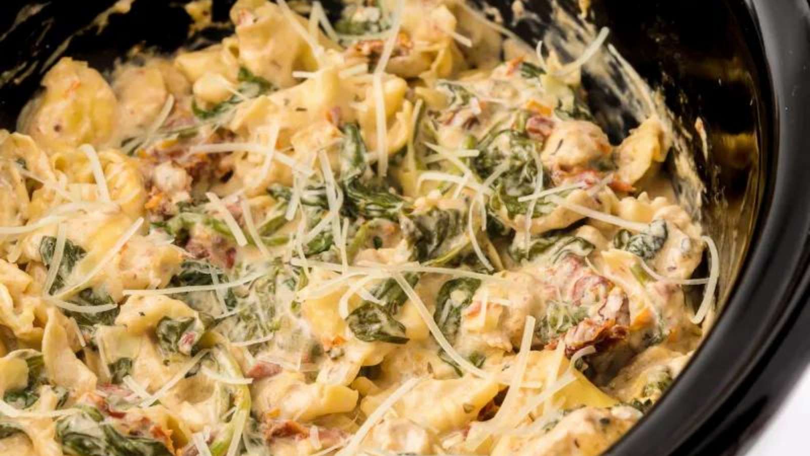 A crock pot filled with spinach and cheese.