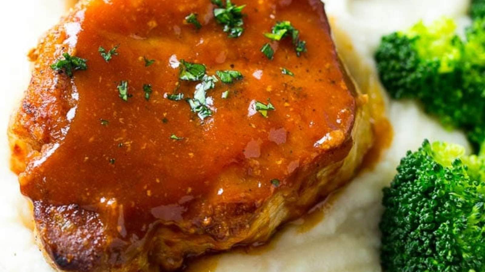 Pork chops with gravy and broccoli on a plate.