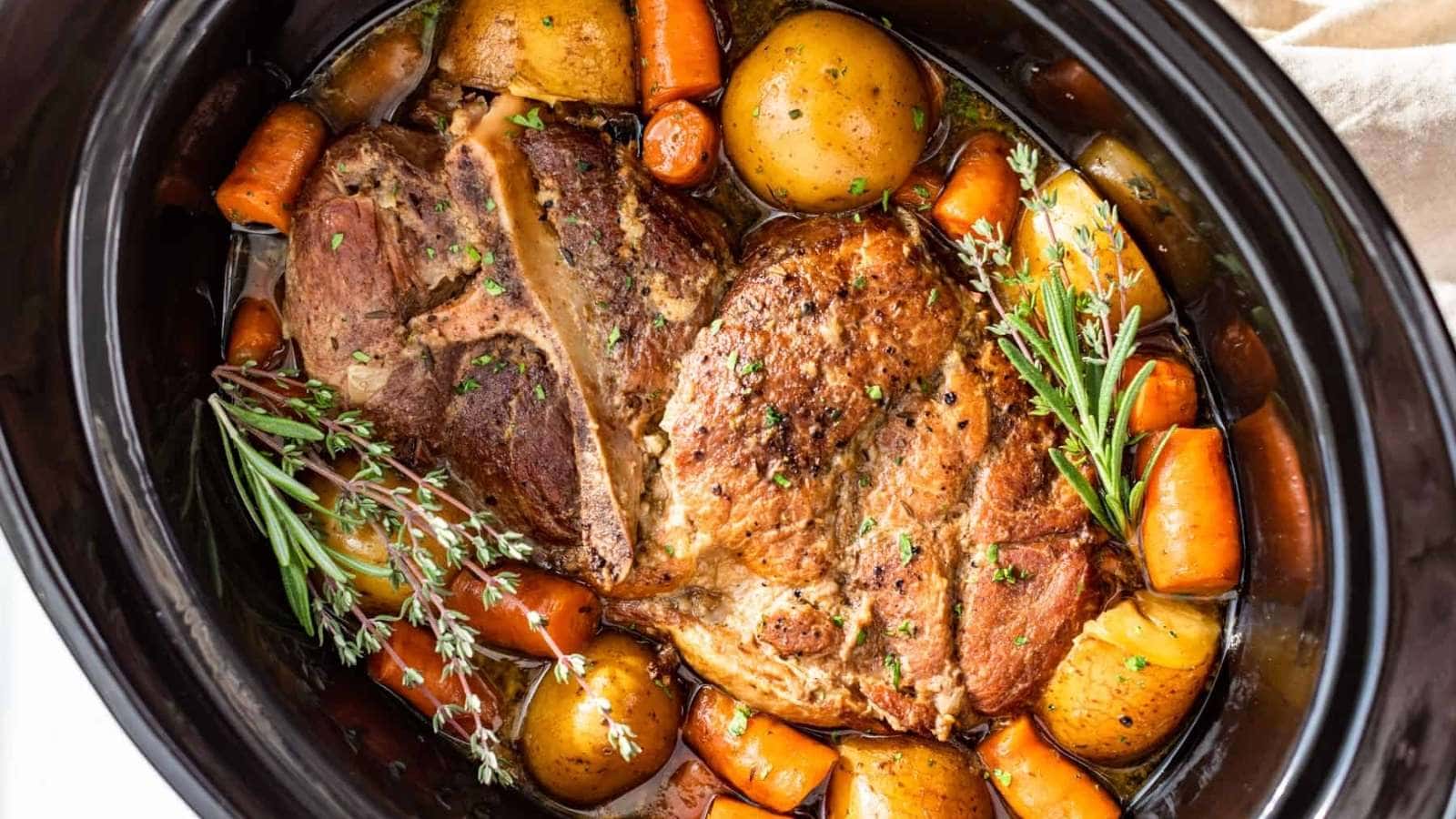 A crock pot full of meat, potatoes and carrots.