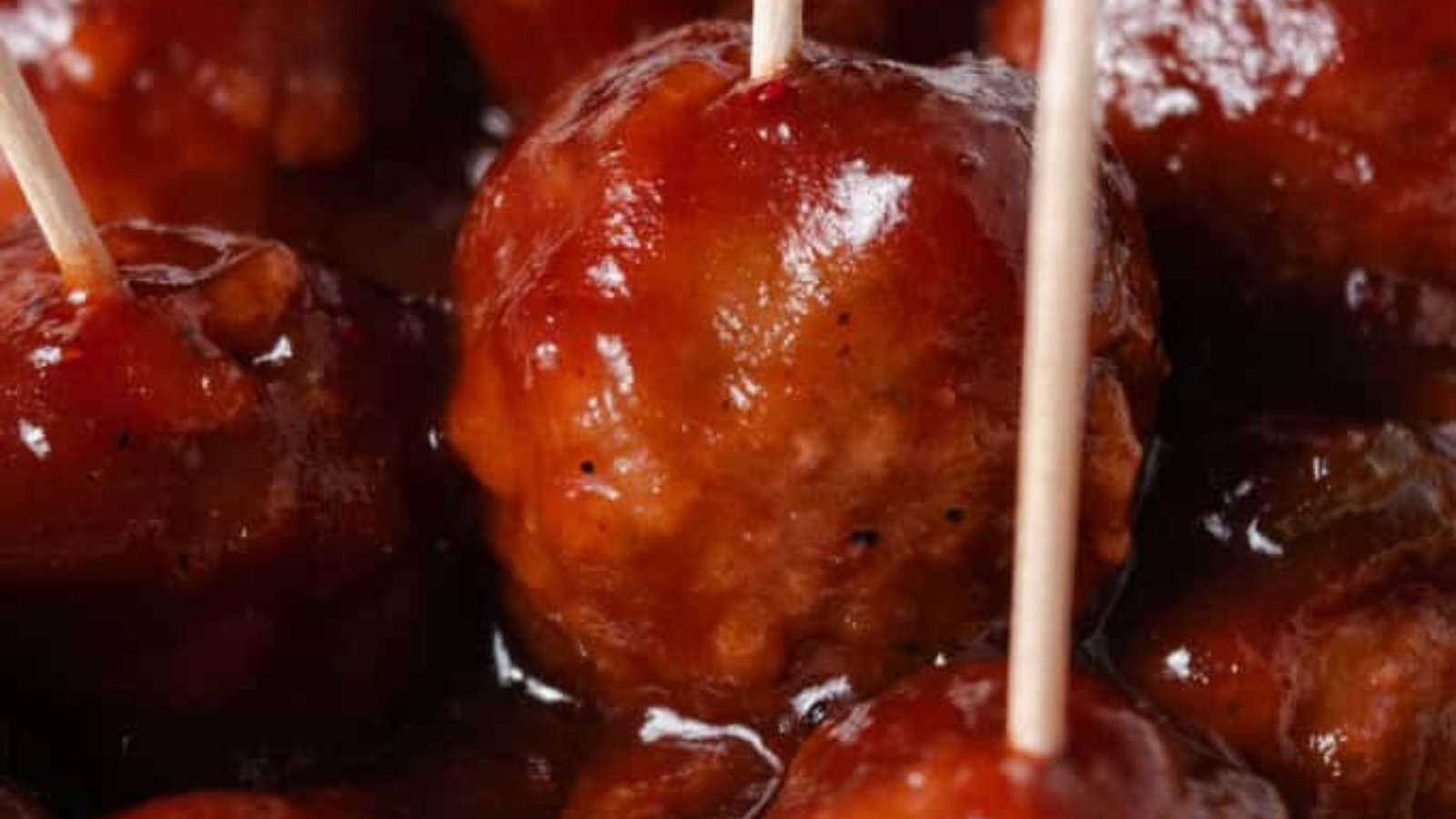 Meatballs with toothpicks on a plate.